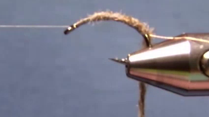 Poly yarn cord tied from front to back and thread returned behind hook eye.