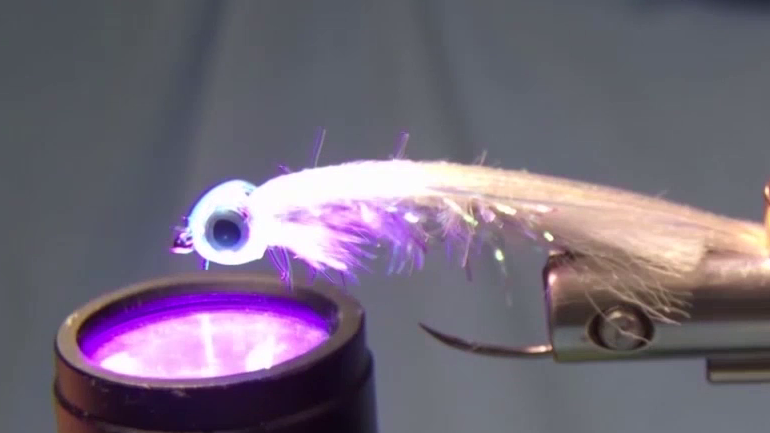 A fresh coat of UV resin applied; the fish mask is pushed onto the hook and cured to secure it firmly in place.